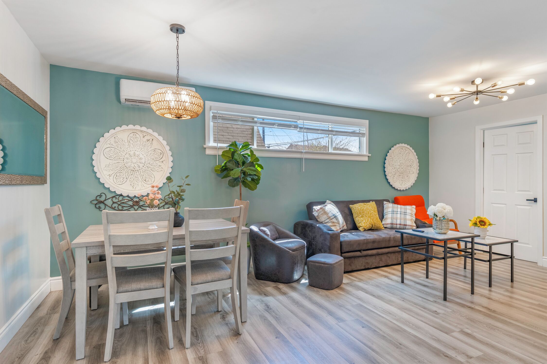 A living room with a dining table, chairs, a sofa, and a coffee table.