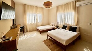 Une chambre avec deux lits simples, un bureau, une chaise et un téléviseur.