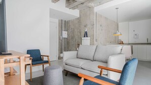 A modern living room with a sofa, chairs, a coffee table, and a television. - Eugenio Exclusive Stylish 1 BR in Sao Paulo (São Paulo)