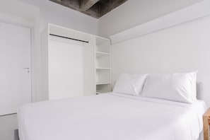 Un dormitorio con cama, paredes blancas y armario con estantes abiertos.
