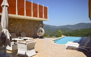 A poolside area with lounge chairs, a hanging chair, and a view of mountains. - Pantokrator Private Pool Gem - Lux Villa in Corfu (Corfu)