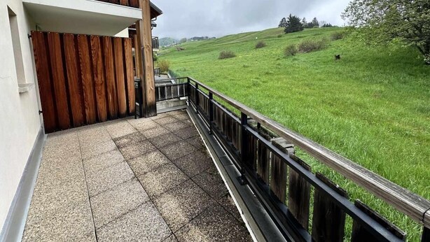 A balcony with a wooden railing overlooking a green field. - 1st floor, balcony, tv, 35m², Villard de Lans (Villard-de-Lans)