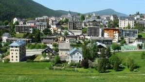 A town with a mix of traditional and modern buildings, including a prominent church spire. - 1st floor, balcony, tv, 35m², Villard de Lans (Villard-de-Lans)