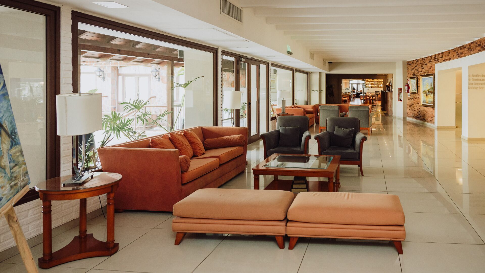 Eine großzügige Lobby mit einer Couch, Sesseln, einem Couchtisch und einer Lampe.