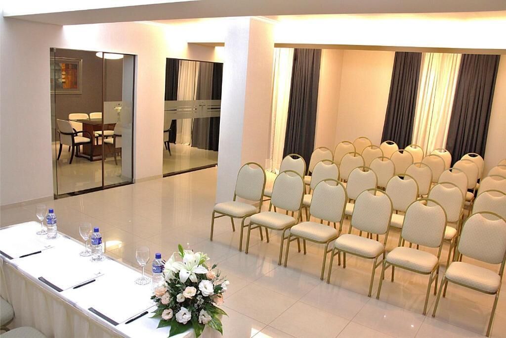 A conference room with a long table, chairs, and a floral arrangement.