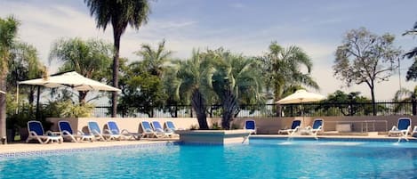 Piscine intérieure, piscine extérieure, parasols, chaises longues