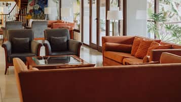 Una sala de estar moderna con sofás de cuero, una mesa de centro de vidrio y una escalera con barandilla.