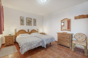 A bedroom with two beds, a dresser, a chair, a mirror, and artwork on the wall. - Country House 'El Moral' with Sea View, Shared Terrace and Wi-Fi (Valverde)
