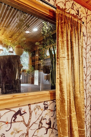 A room with a large window, a wooden ceiling, and a curtain with a tree branch pattern. - Morning Star - Western Charm and Monkey Magic! (Valley View)