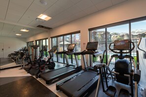 Ein Fitnessraum mit Laufbändern, Crosstrainern und Kraftgeräten.