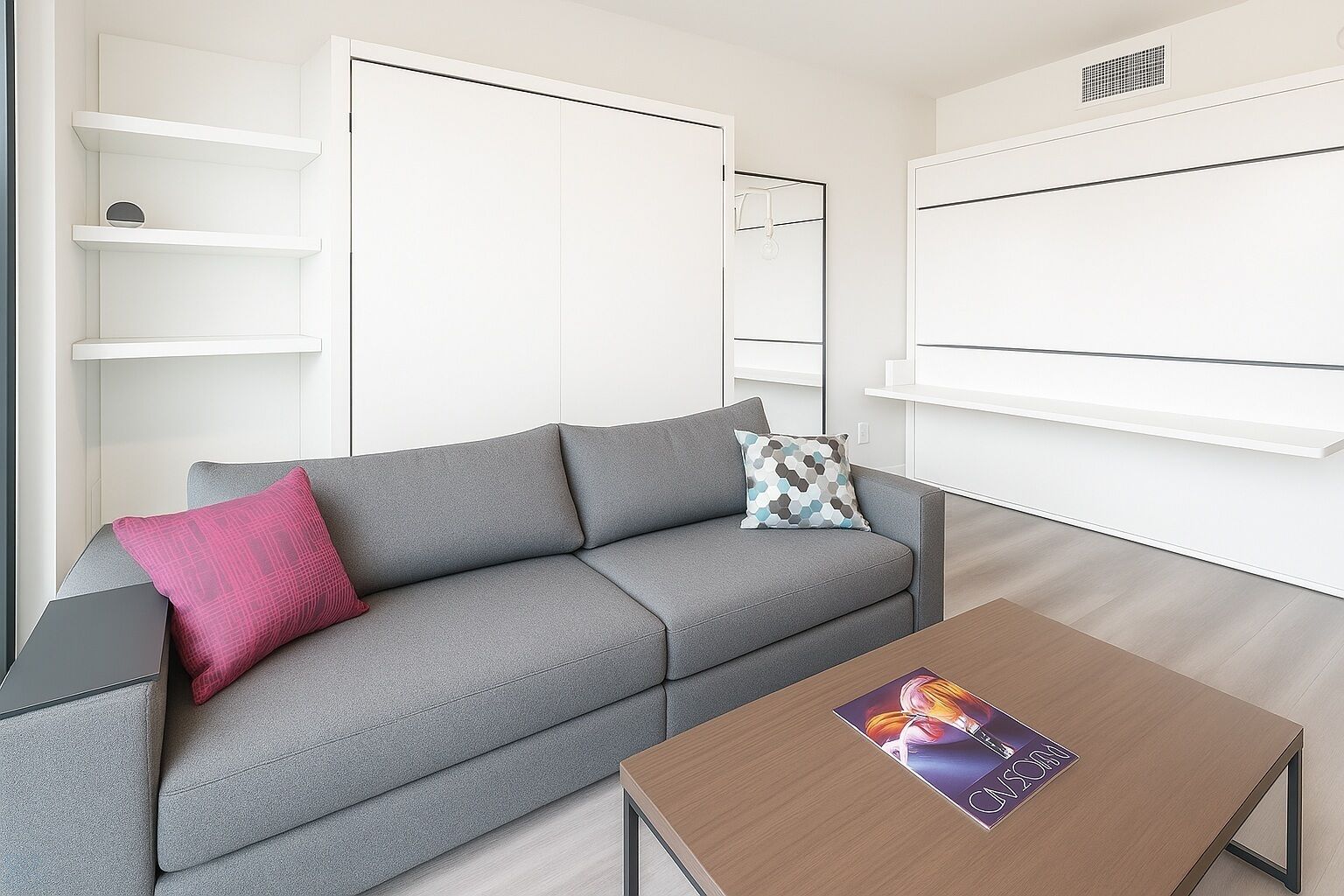 Una sala moderna con un sofá gris, una mesa de centro de madera y estanterías blancas.