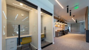 A modern office space with glass partitions, a meeting area with chairs, and a reception desk. - The Ski Pad by Park City Vacations (Park City)