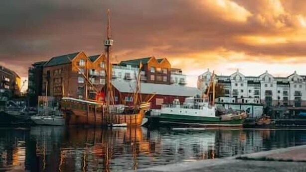 Een watergezicht met traditionele gebouwen en een groot schip in de haven.