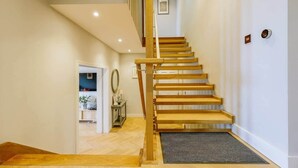 Eine Treppe mit Holzstufen und Handlauf, die zu einer oberen Etage führt.