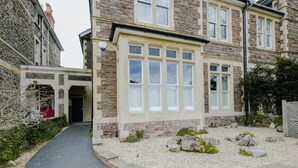 A stone building with a garden area, a paved walkway, and a small entrance. - Victorian Charm in Cotham | Free Parking (Bristol)