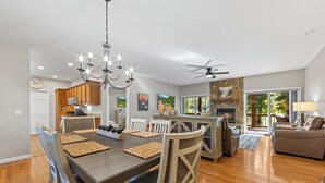 Una cocina amplia con comedor, piso de madera y chimenea de piedra.