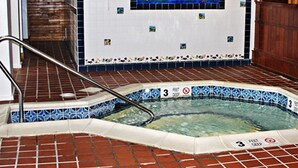 An indoor swimming pool with a tiled edge, a handrail, and a '3 feet deep' sign. - Crafts Inn, Hotel Suite with pool and hot tub. (Wilmington)