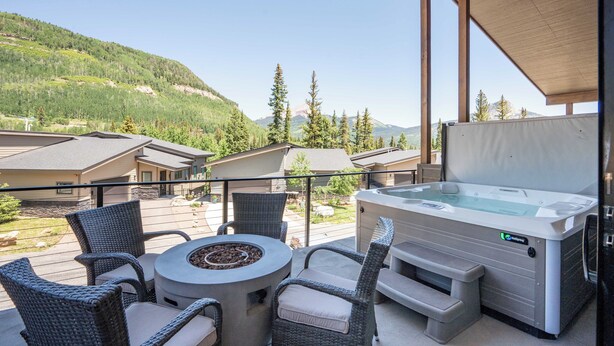 A balcony with wicker chairs, a hot tub, and a view of a mountain landscape. - Super clean 3-bedroom townhome- Purgatory - Hot Tub/Views/Arcade Game/Firepit (Durango)