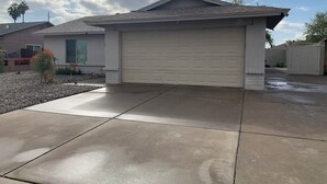 A residential garage with a concrete driveway and a clear sky. - Free RV parking, two car garage, fenced backyard, minutes to Westgate (Glendale)