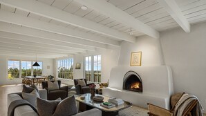 A spacious living room with a fireplace, modern furniture, and large windows offering a view of the outdoors. - Gorgeous Newly Renovated Luxury Home Located 1 mile to Plaza Avail May 23- Aug 7 (Santa Fe)