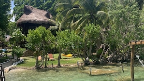 A tropical resort with a clear pool, wooden deck, and thatched-roof structures. - Kuuch Kaanil Villas Eco-romanticas  (Bacalar)