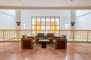 A lobby with a seating area, a glass table, and a railing. - Hotel Bumi Siliwangi by My Hospitality (Sukasari)