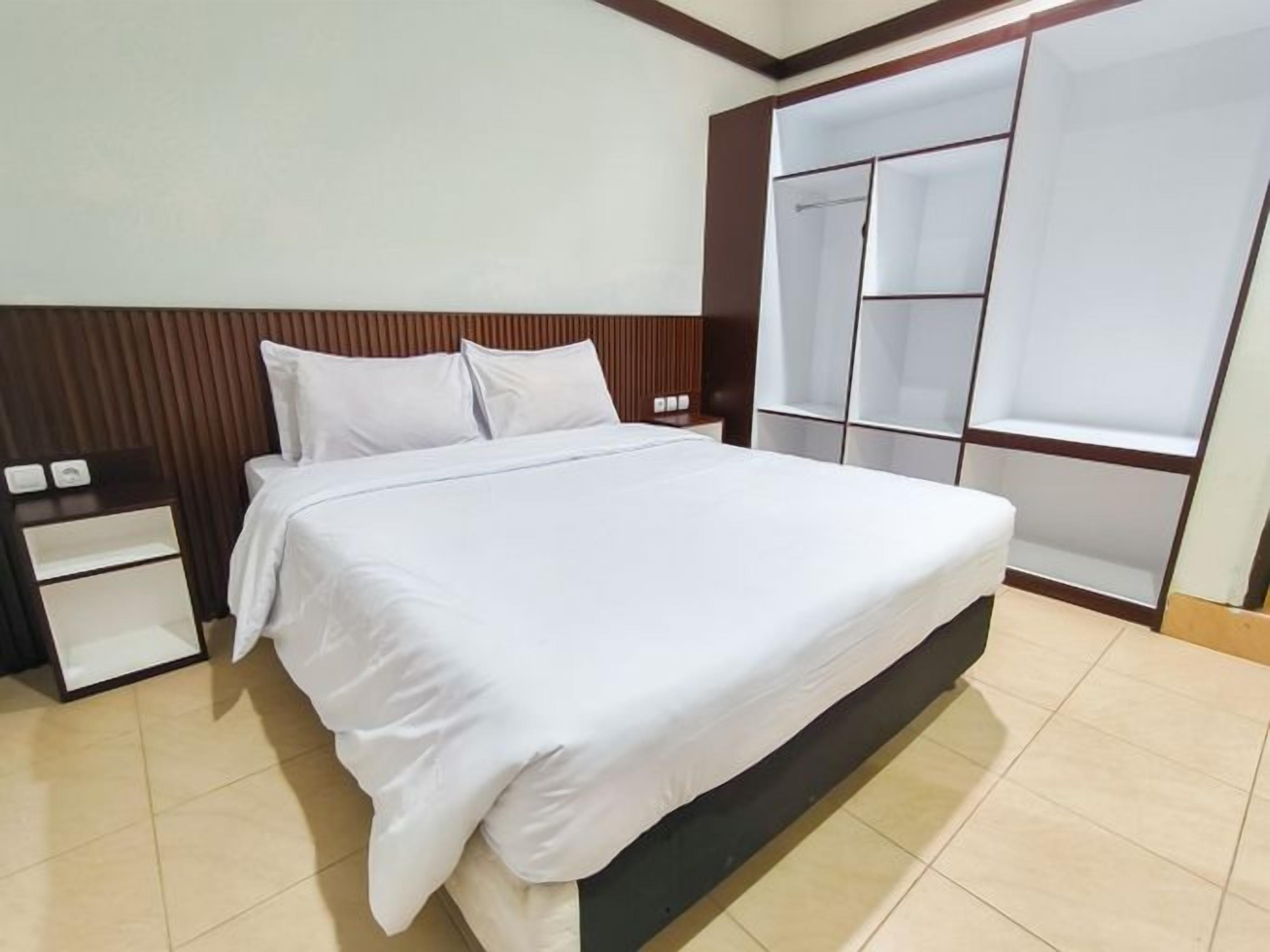 A bedroom with a bed, nightstand, and built-in wardrobe.
