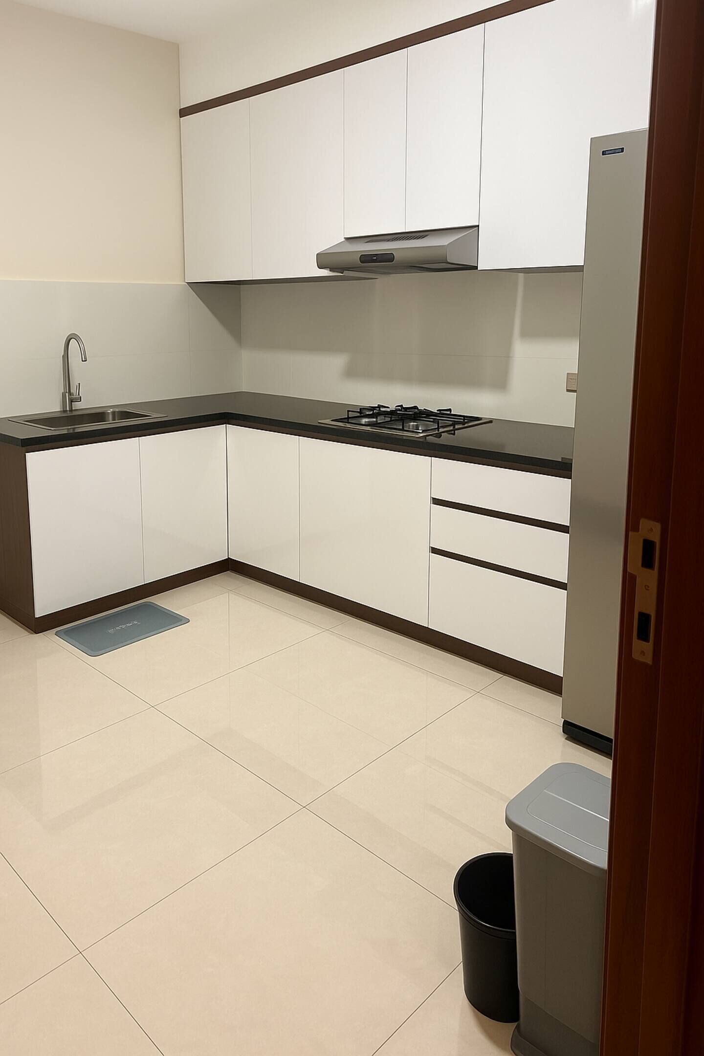 A modern kitchen with white cabinets, a black countertop, a gas stove, and a stainless steel sink.