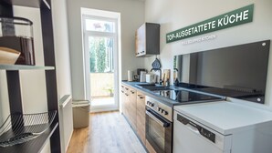 Una cocina moderna con equipamiento completo, que incluye estufa, horno y lavavajillas.