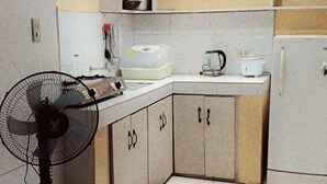 Una cocina compacta con ventilador, un lavamanos y un refrigerador.