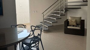 A modern interior with a spiral staircase, a dining area with chairs, and a sofa. - D'Santa Lofts - Penha - SC (Penha)