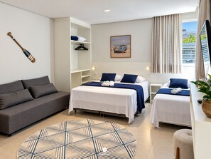 A hotel room with a sofa, two beds, a wardrobe, a painting, and a view of the outdoors. - D'Santa Lofts - Penha - SC (Penha)