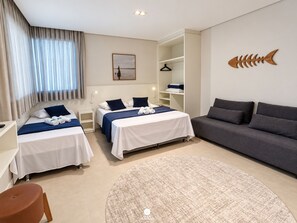 A hotel room with two beds, a sofa, a round rug, and a fish decoration on the wall. - D'Santa Lofts - Penha - SC (Penha)