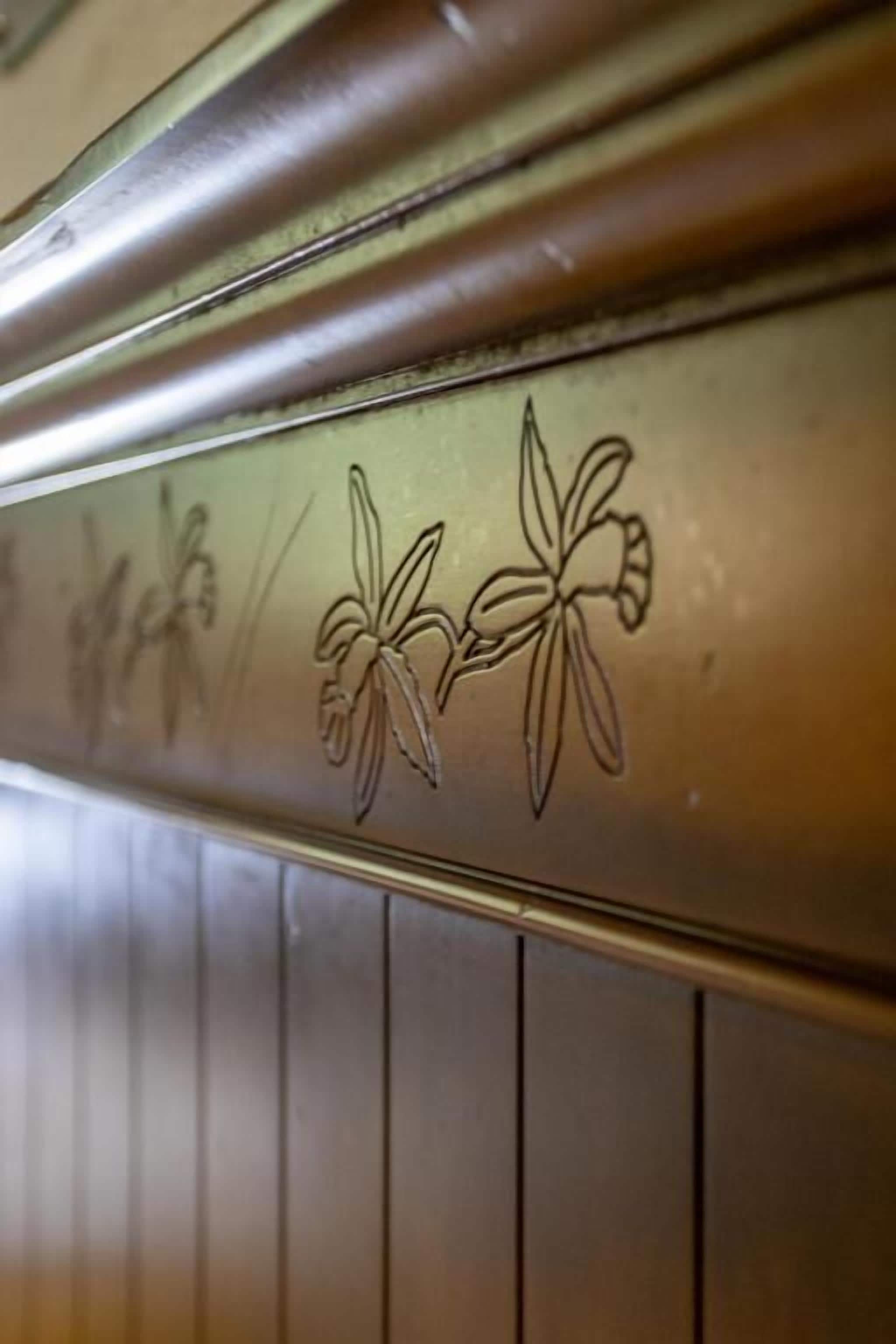Primer plano de una superficie metálica con diseños florales en relieve.