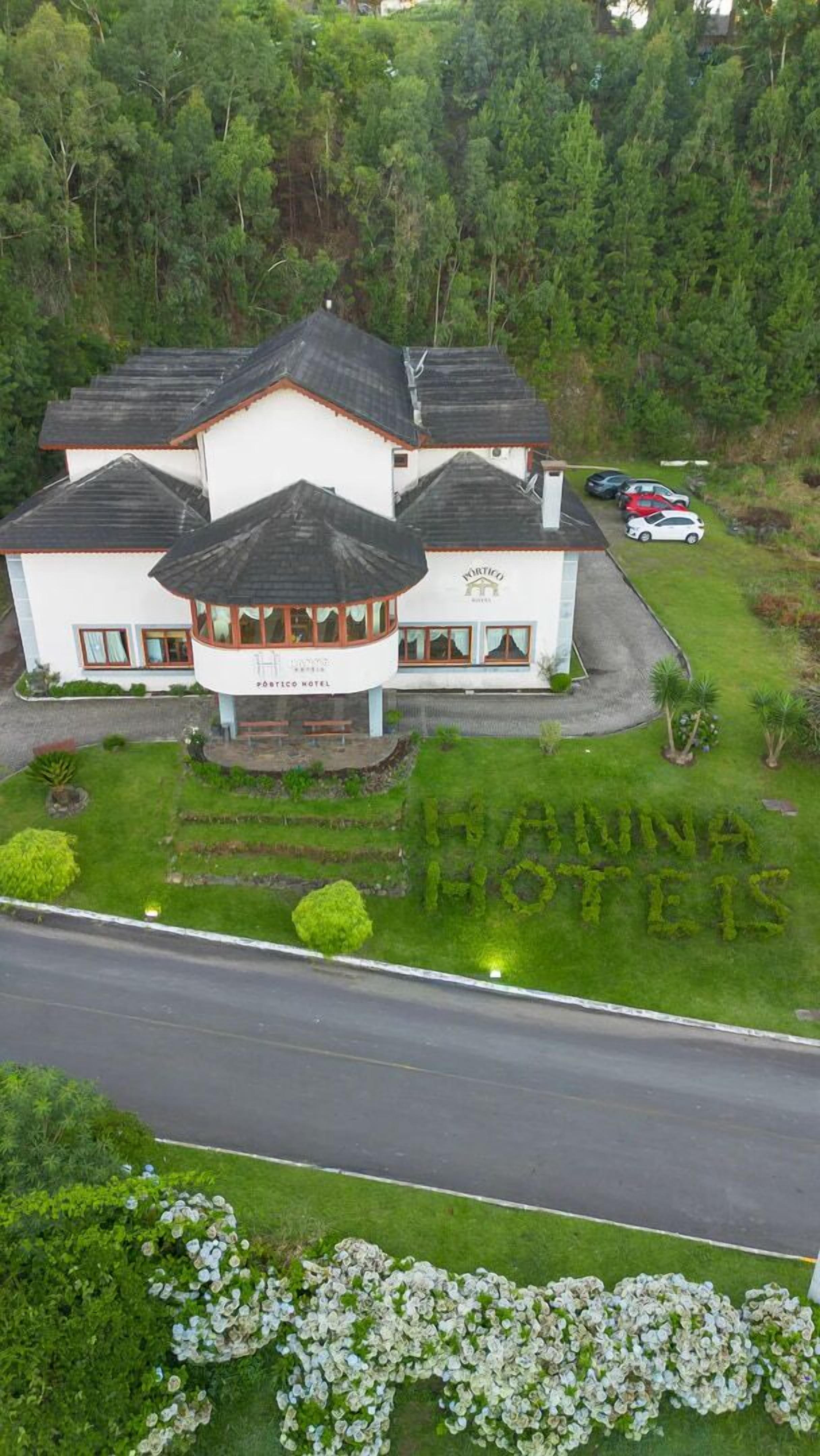 A hotel with a central courtyard, a covered seating area, and a parking lot.