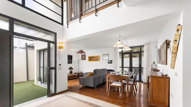 A spacious living area with a dining table, sofa, and a staircase leading to an upper level. - Villa Paula - Three Bedroom Villa, Sleeps 6 (Costa Teguise)