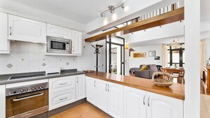 A modern kitchen with white cabinets, a stainless steel oven, and a microwave. - Villa Paula - Three Bedroom Villa, Sleeps 6 (Costa Teguise)