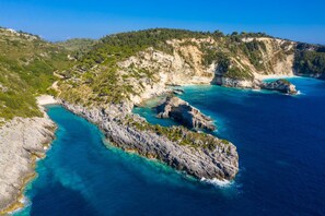 A coastal landscape with rocky terrain and clear blue waters.