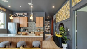 A modern kitchen with a central island, wooden cabinets, and a decorative animal headpiece above the island.