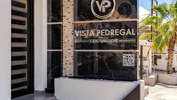 Een moderne entree met een bordje voor 'Vista Pedregal Cabo San Lucas' en een QR-code.
