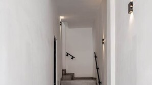 Un escalier moderne au design minimaliste, menant à l’étage supérieur.