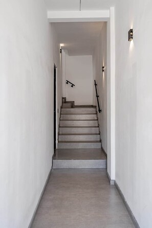 Eine moderne, minimalistisch gestaltete Treppe, die zu einer oberen Etage führt.