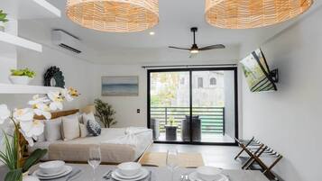 A modern bedroom with a bed, bedside table, and a view of a building through a glass door.