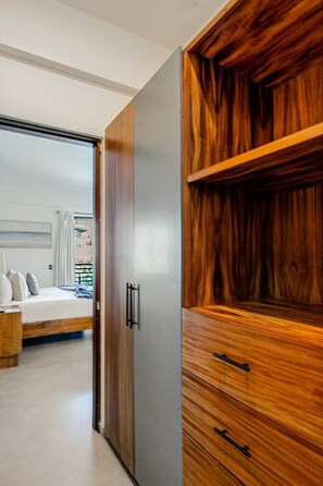 A bedroom with a bed, a wardrobe, and a view of the outside.