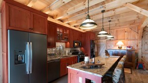 Una cocina moderna con armarios de madera, electrodomésticos de acero inoxidable y una isla central con asientos.