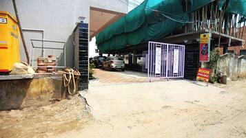 A construction site with a partially built structure, a gated entrance, and a sign indicating a room is available.