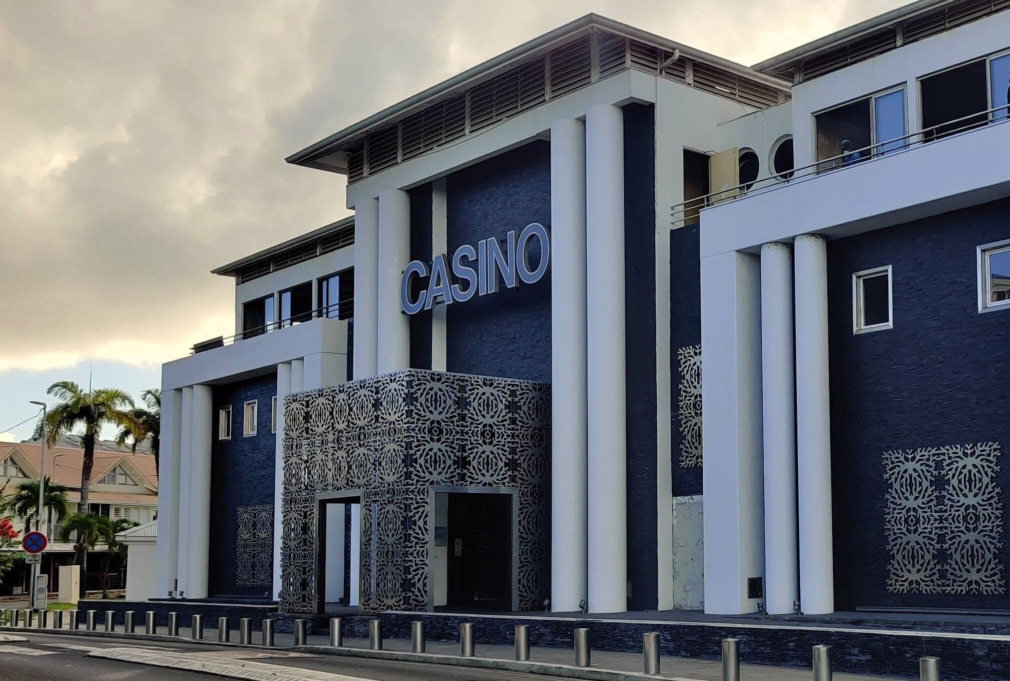 Un bâtiment moderne, orné d'une enseigne bien visible indiquant « CASINO », avec une façade symétrique agrémentée de motifs décoratifs et de grandes fenêtres.