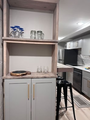A kitchen with a wooden shelf, a countertop, and a refrigerator.