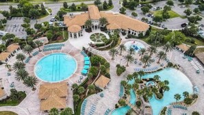 Un complexe hôtelier doté d’une grande piscine centrale, de plusieurs petites piscines et d’un élément décoratif aquatique circulaire.