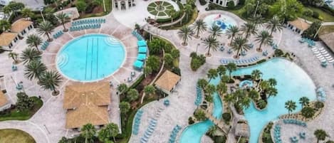 A resort with a large central pool, smaller pools, and a circular water feature.